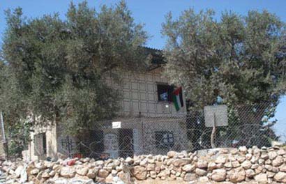 Les colons enlèvent le drapeau palestinien flottant à la fenêtre de la maison d'Issa à Tel-Rumeida