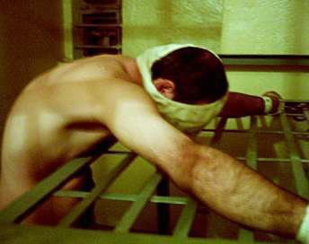 Un gardien de prison sioniste prend un détenu en photo pendant une fouille à nu