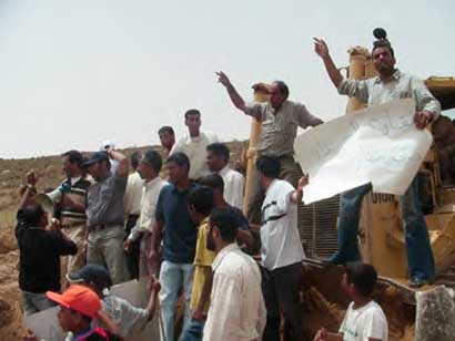 Des villageois montent sur un bulldozer à AL Ramadin